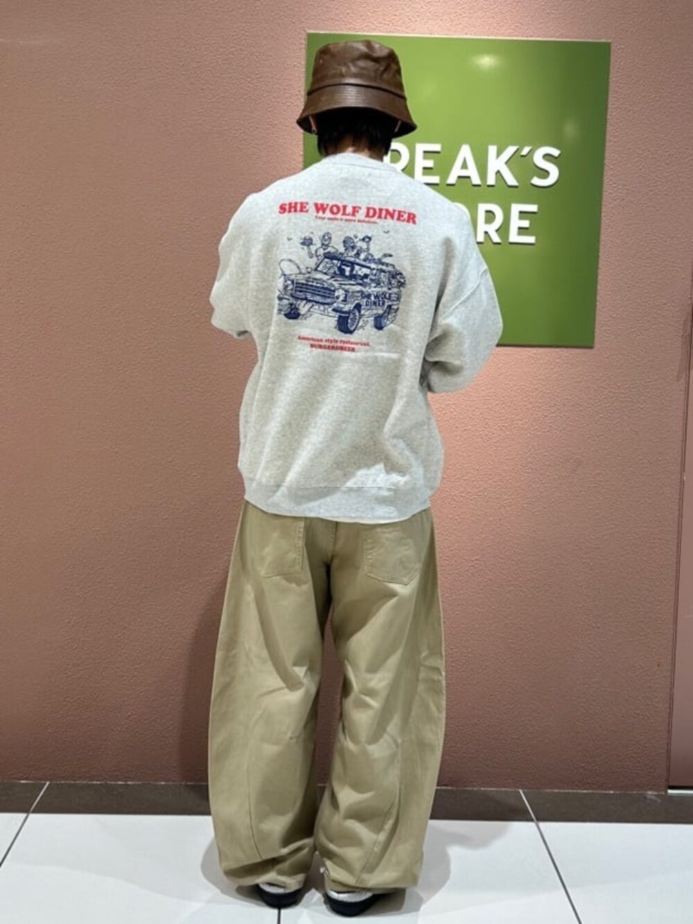 シルバー系のサンダル、イエロー系のチノパンツ、グレー系のスウェットを着用したメンズの秋コーディネートの3枚目の写真