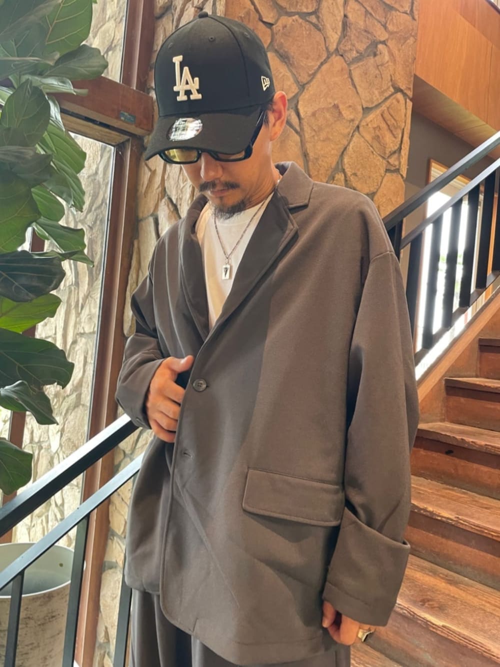 グレー系のセットアップ、ブラック系のキャップを着用したメンズの夏コーディネートの4枚目の写真