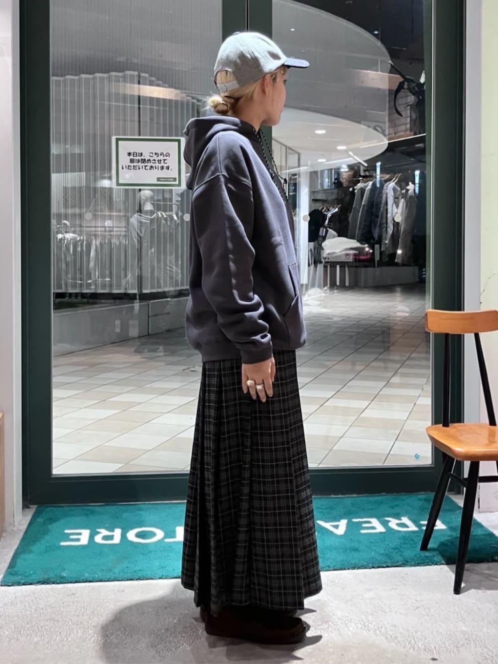 ブラック系のパーカー、ブラック系のスカート、グレー系のキャップを着用したレディースの秋コーディネートの2枚目の写真