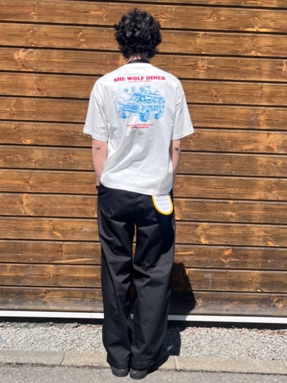 ブラック系のチノパンツ、ホワイト系のTシャツ/カットソーを着用したメンズの夏コーディネートの3枚目の写真