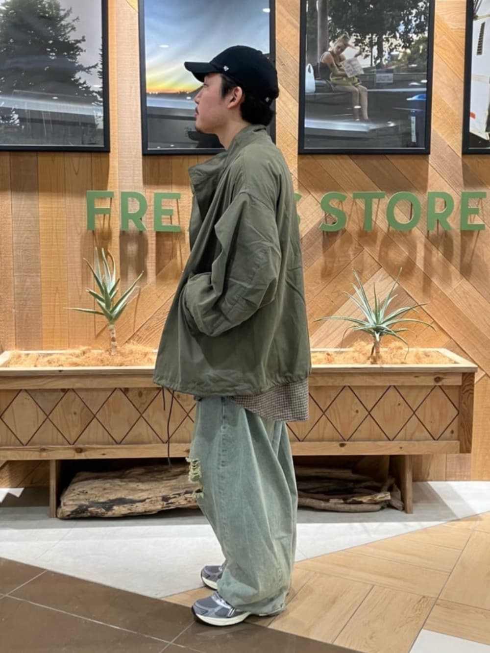 ブルー系のデニムパンツ、グリーン系のブルゾン、ブラウン系のシャツ/ブラウスを着用したメンズの秋コーディネートの2枚目の写真