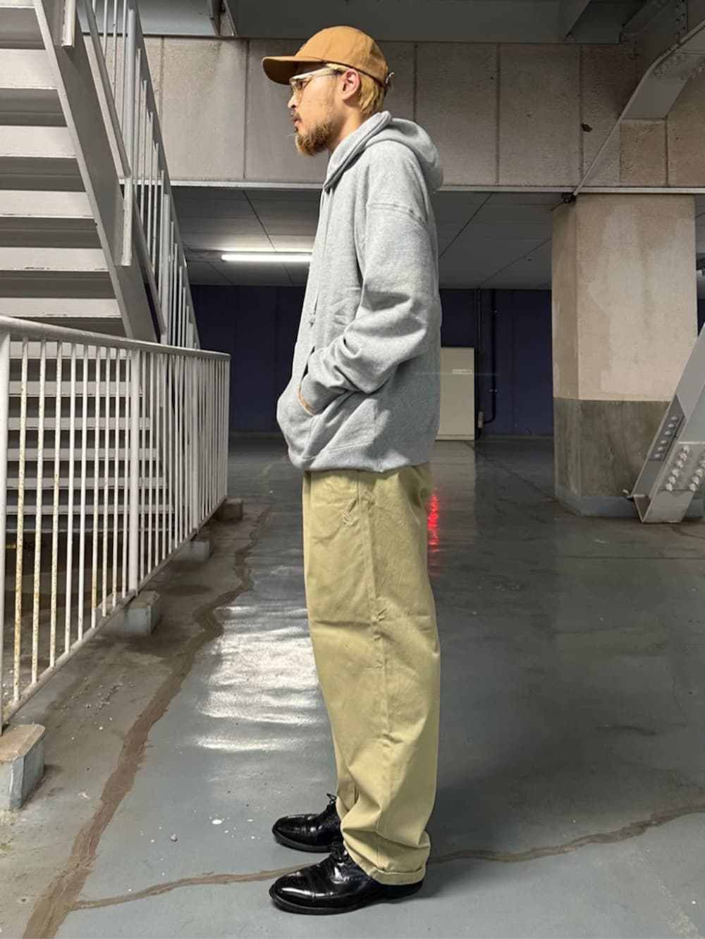 グレー系のパーカー、ベージュ系のチノパンツを着用したメンズの秋コーディネートの2枚目の写真