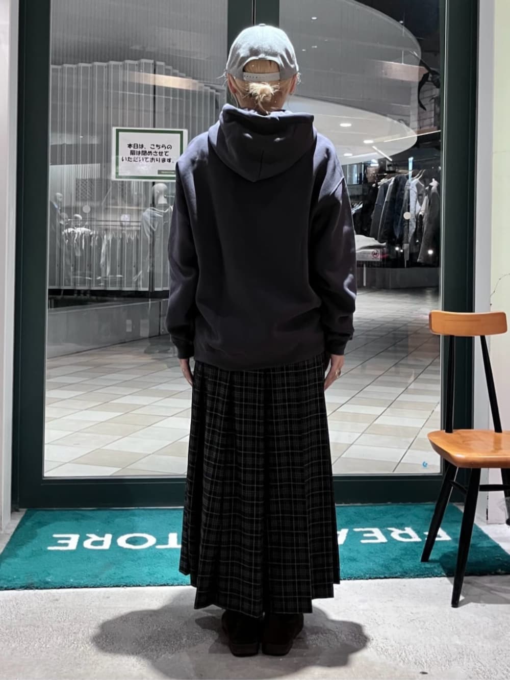 ブラック系のパーカー、ブラック系のスカート、グレー系のキャップを着用したレディースの秋コーディネートの3枚目の写真