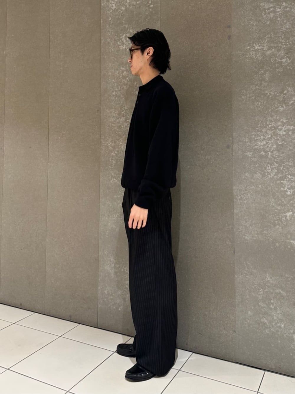 ブラック系のニット/セーター、ブラック系のスラックスを着用したメンズの秋コーディネートの3枚目の写真