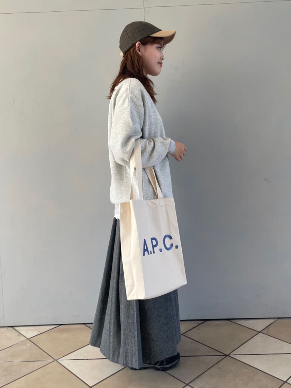 グレー系のスカート、グレー系のスウェット、ホワイト系のTシャツ/カットソーを着用したレディースの秋コーディネートの2枚目の写真