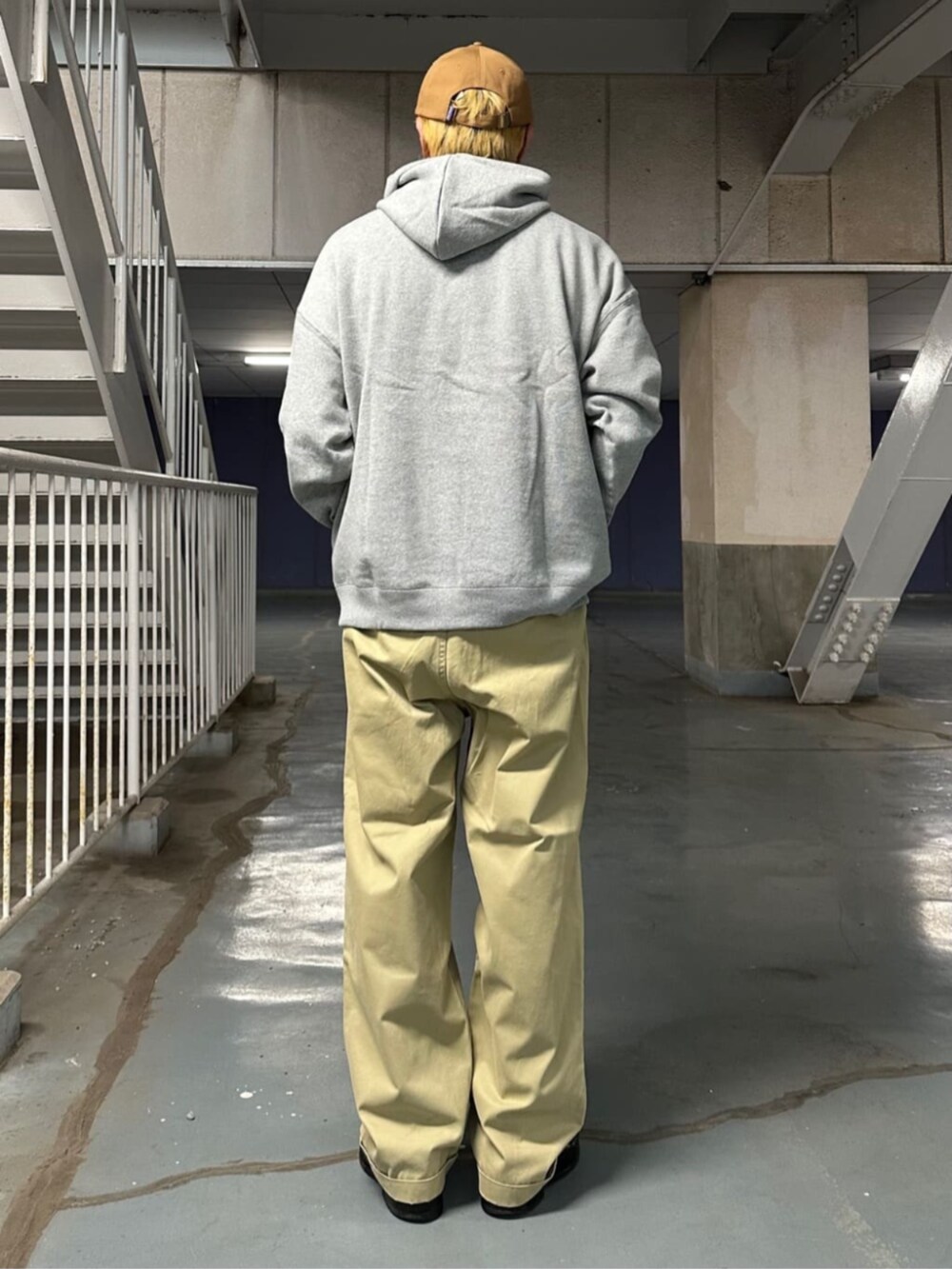 グレー系のパーカー、ベージュ系のチノパンツを着用したメンズの秋コーディネートの3枚目の写真