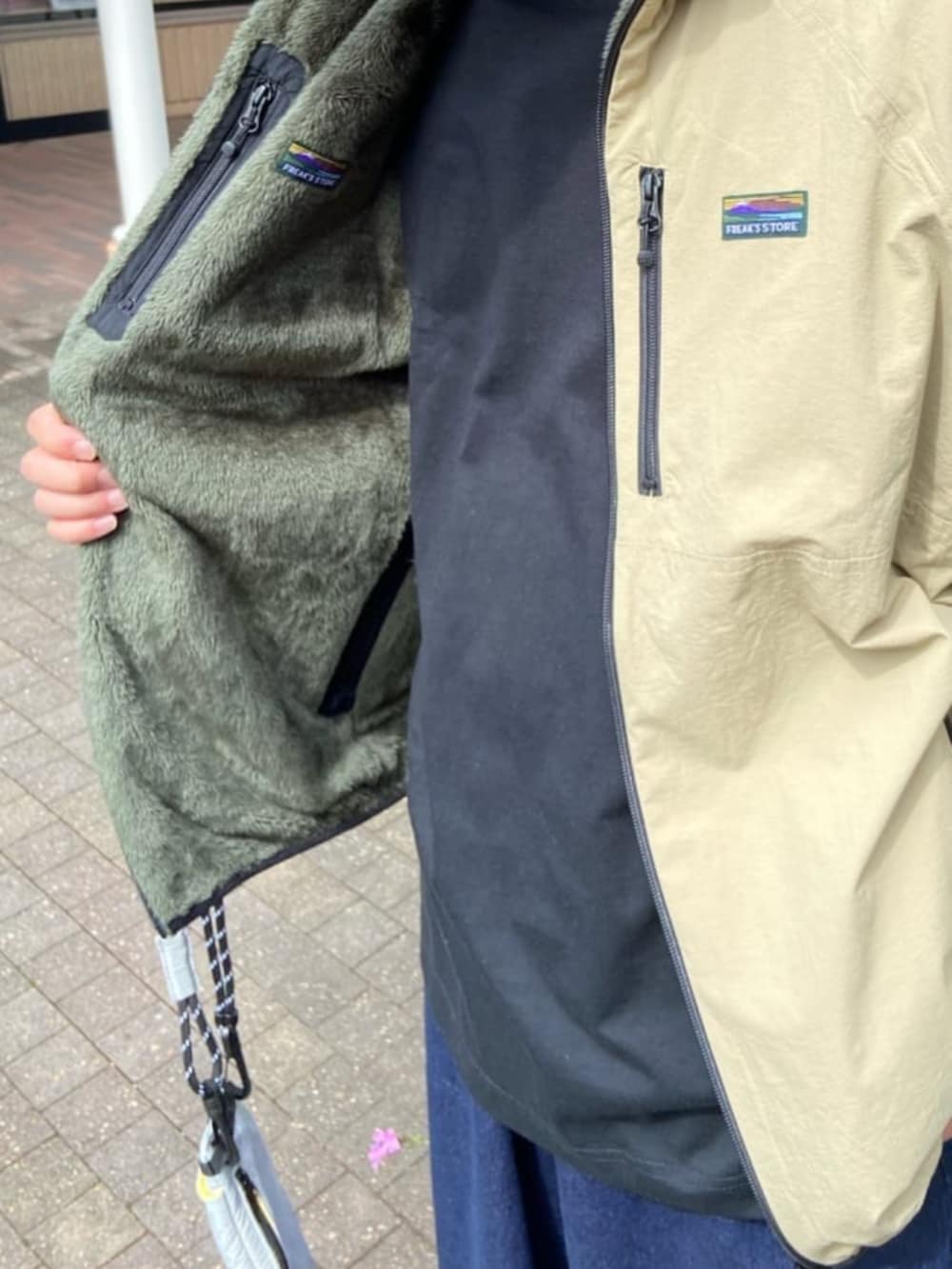 ブルー系のデニムパンツ、ブラック系のTシャツ/カットソー、ベージュ系のブルゾンを着用したメンズの秋コーディネートの4枚目の写真