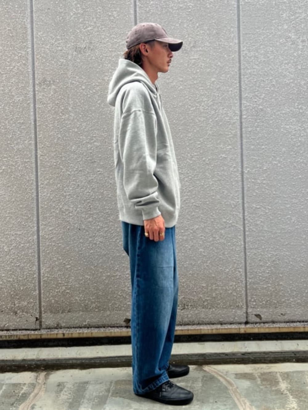 グレー系のパーカー、ブルー系のデニムパンツを着用したメンズの秋コーディネートの2枚目の写真