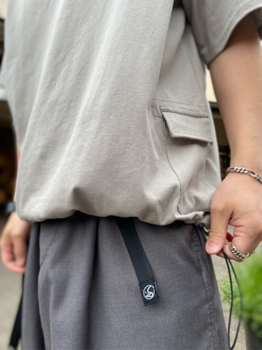 グレー系のスラックス、ベージュ系のTシャツ/カットソーを着用したメンズの春コーディネートの2枚目の写真