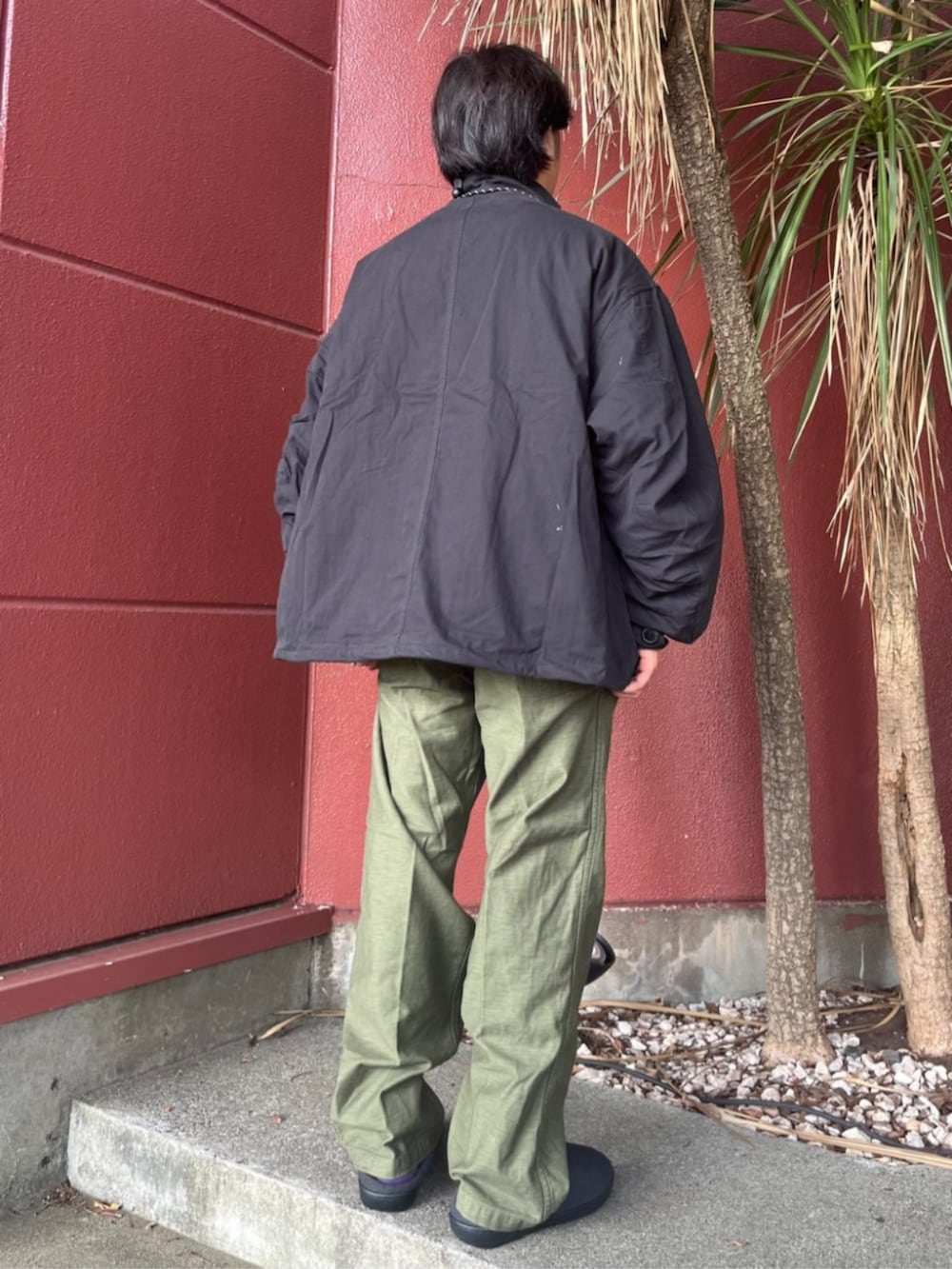 ブラック系のブルゾン、レッド系のコインケースを着用したメンズの秋コーディネートの3枚目の写真