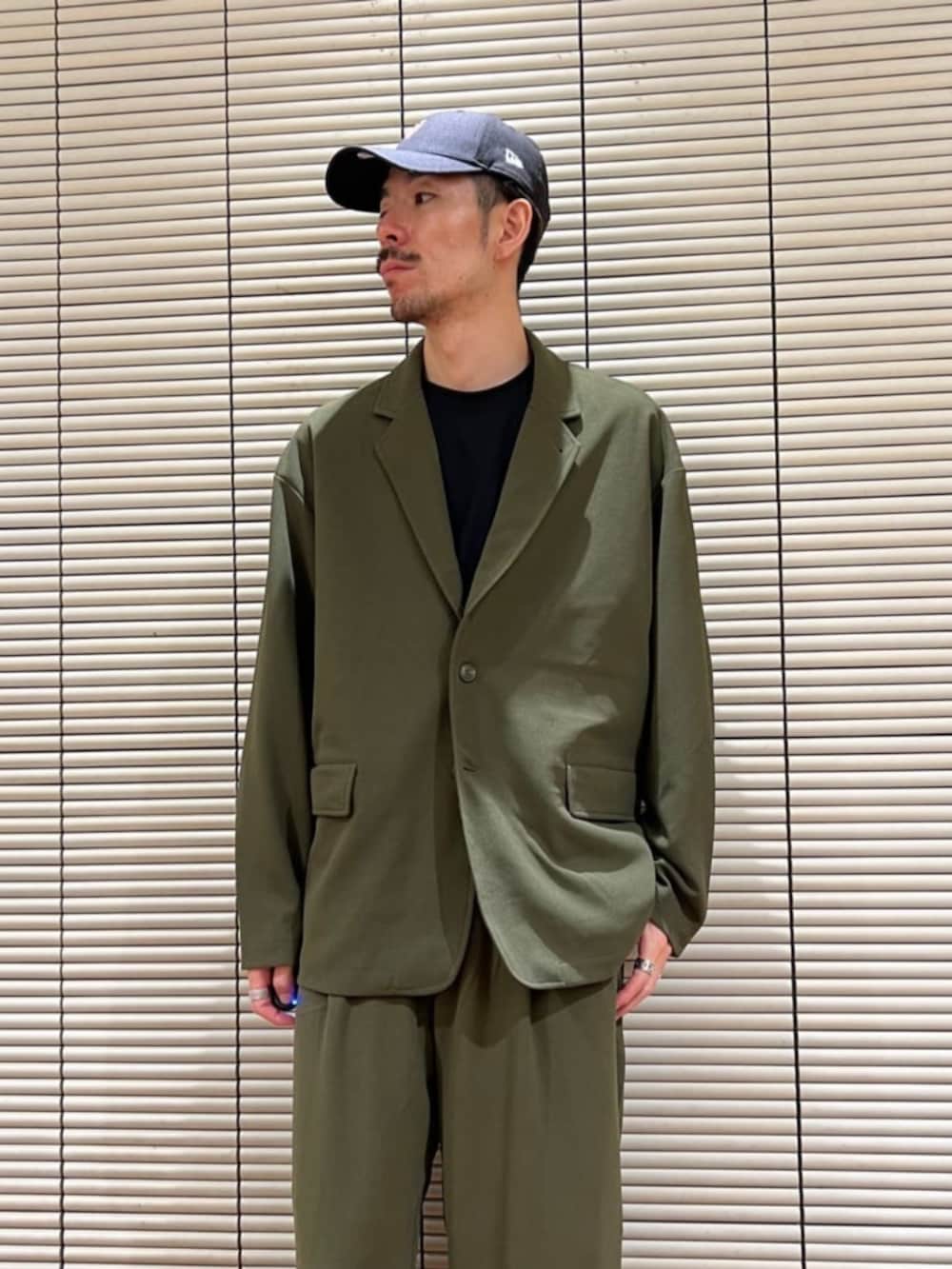 グリーン系のセットアップを着用したメンズの夏コーディネートの3枚目の写真