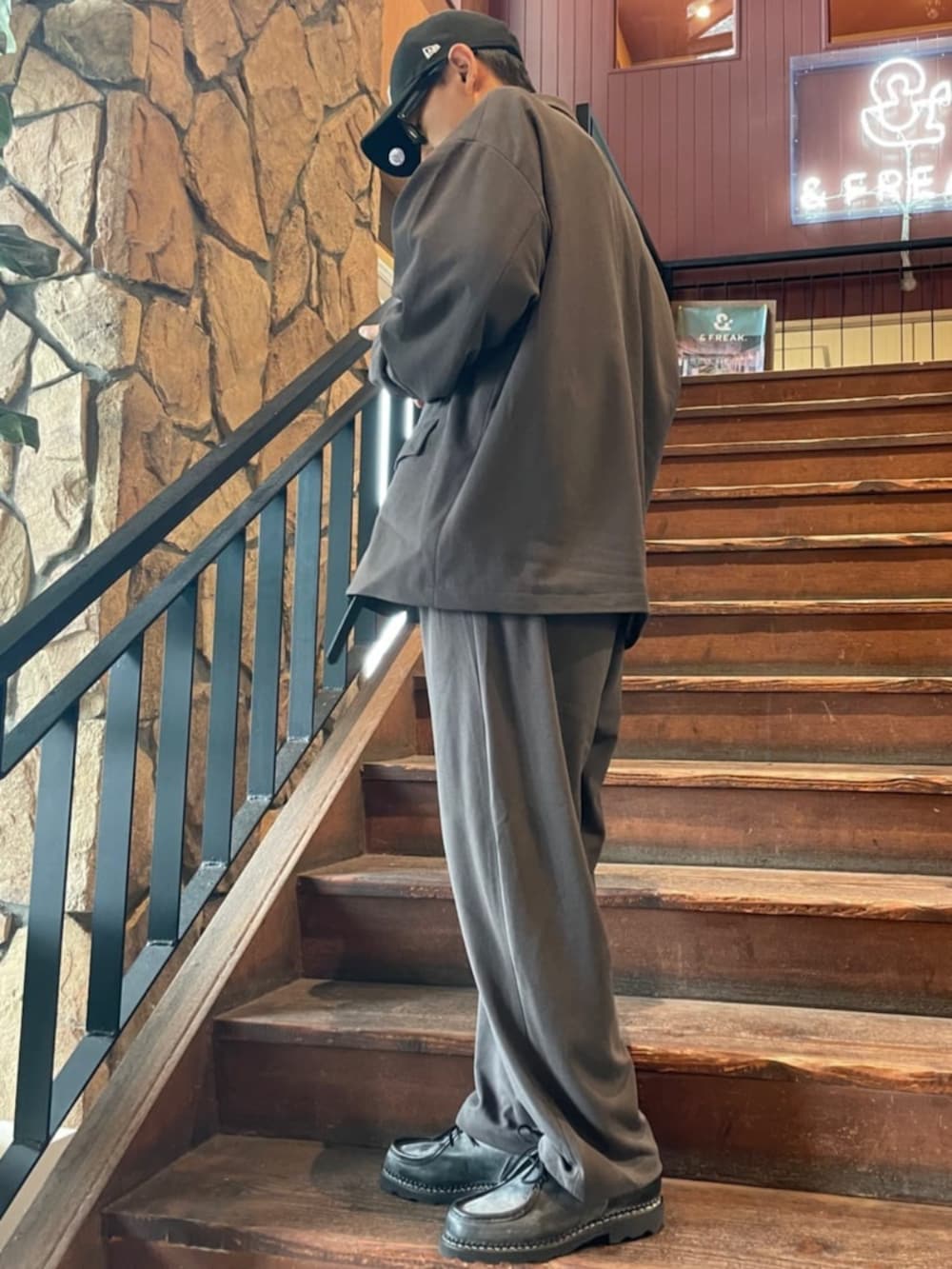 グレー系のセットアップ、ブラック系のキャップを着用したメンズの夏コーディネートの2枚目の写真