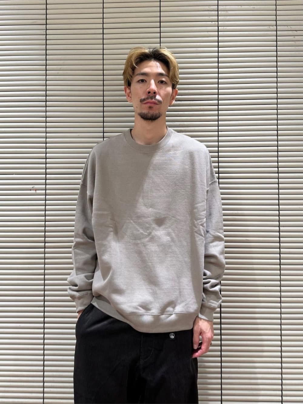 ベージュ系のスウェット、グレー系のその他パンツを着用したメンズの秋コーディネートの2枚目の写真