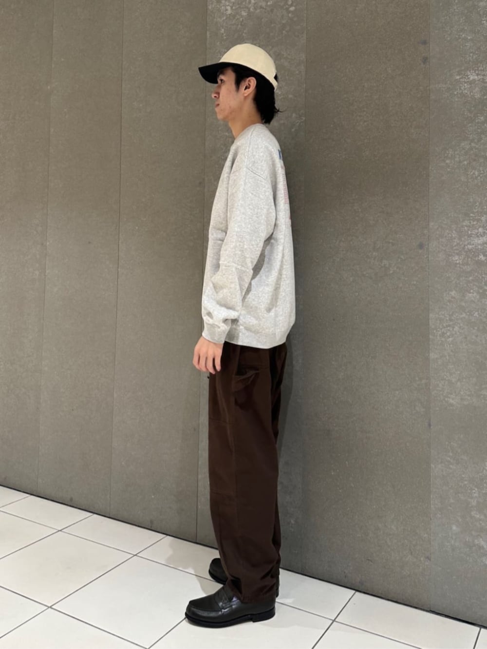 グレー系のスウェット、ブラウン系のその他パンツ、ホワイト系のキャップを着用したメンズの秋コーディネートの4枚目の写真