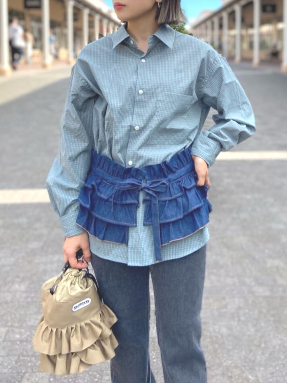 ベージュ系のショルダーバッグ、ブルー系のシャツ/ブラウス、ブラック系のデニムパンツを着用したレディースの夏コーディネートの4枚目の写真