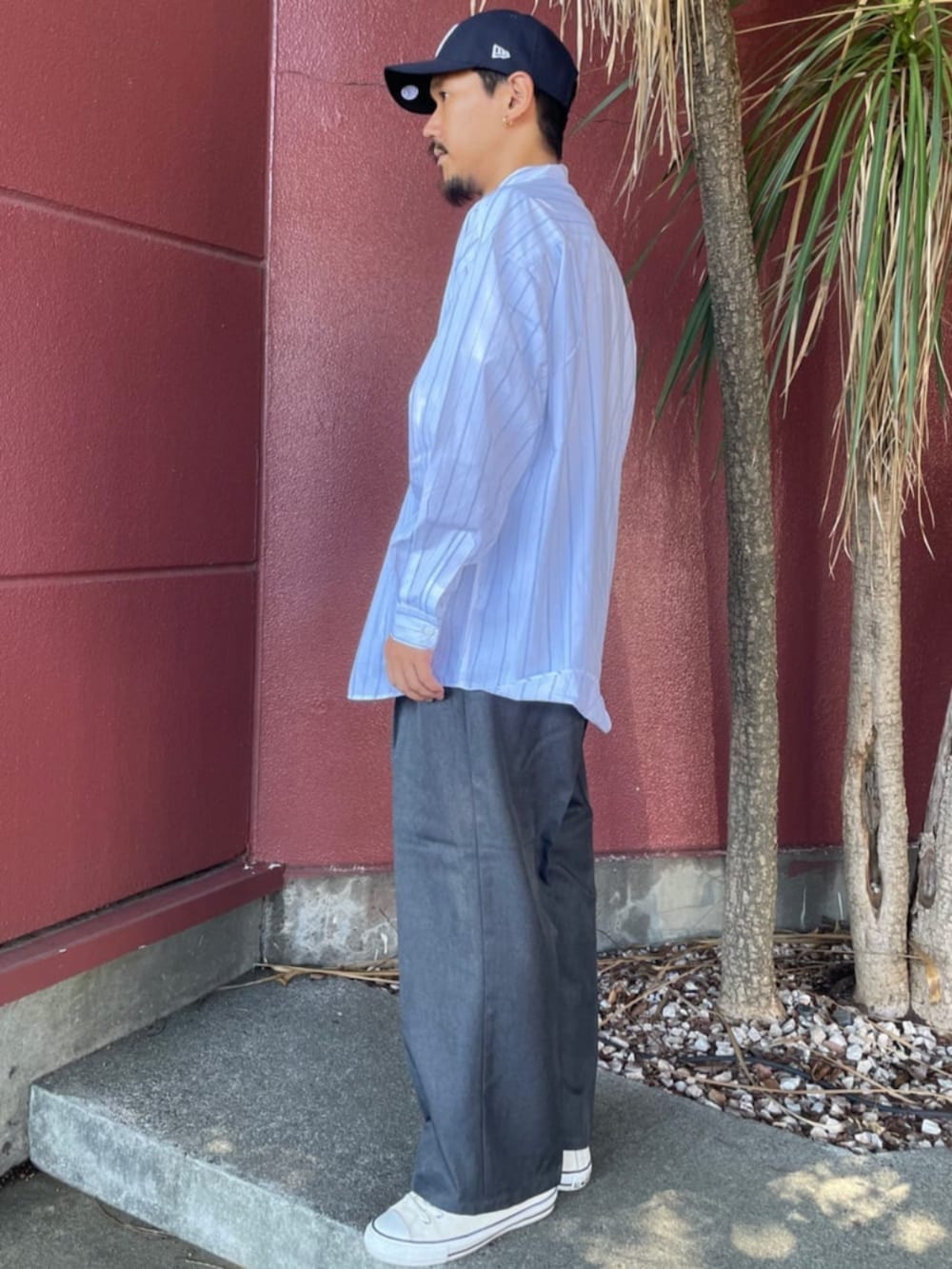 ホワイト系のシャツ/ブラウス、グレー系のスラックス、ブルー系のキャップを着用したメンズの夏コーディネートの2枚目の写真