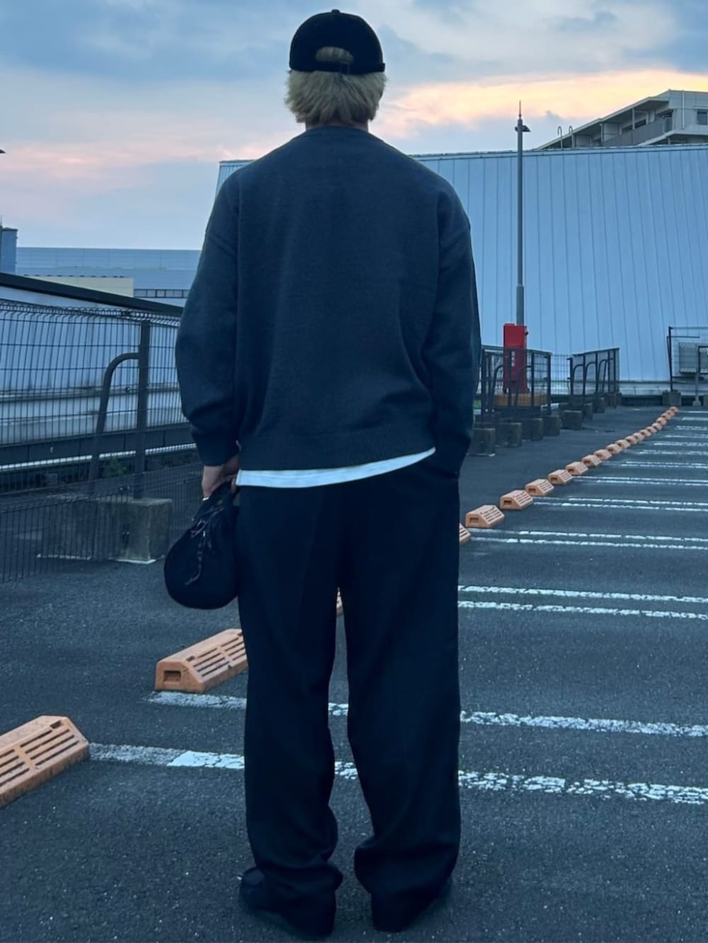 ブラック系のスラックス、グレー系のニット/セーターを着用したメンズの秋コーディネートの3枚目の写真