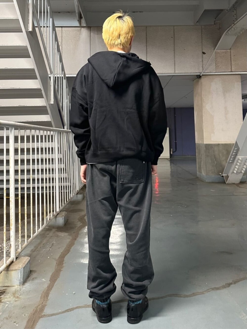 ブラック系のパーカー、ブラック系のスウェットパンツを着用したメンズの秋コーディネートの3枚目の写真