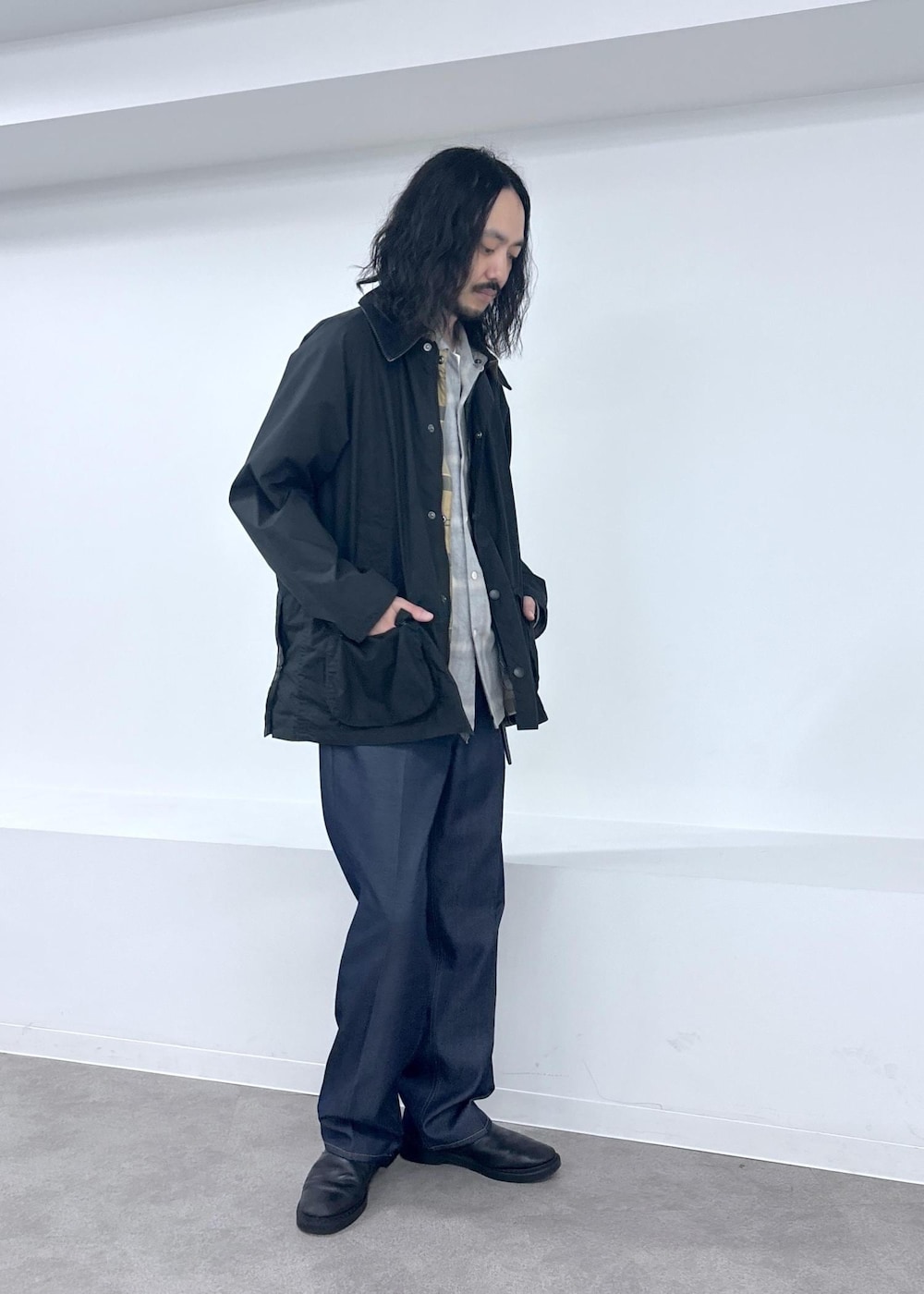 ブラック系のブルゾン、ブルー系のデニムパンツを着用したメンズの夏コーディネートの5枚目の写真