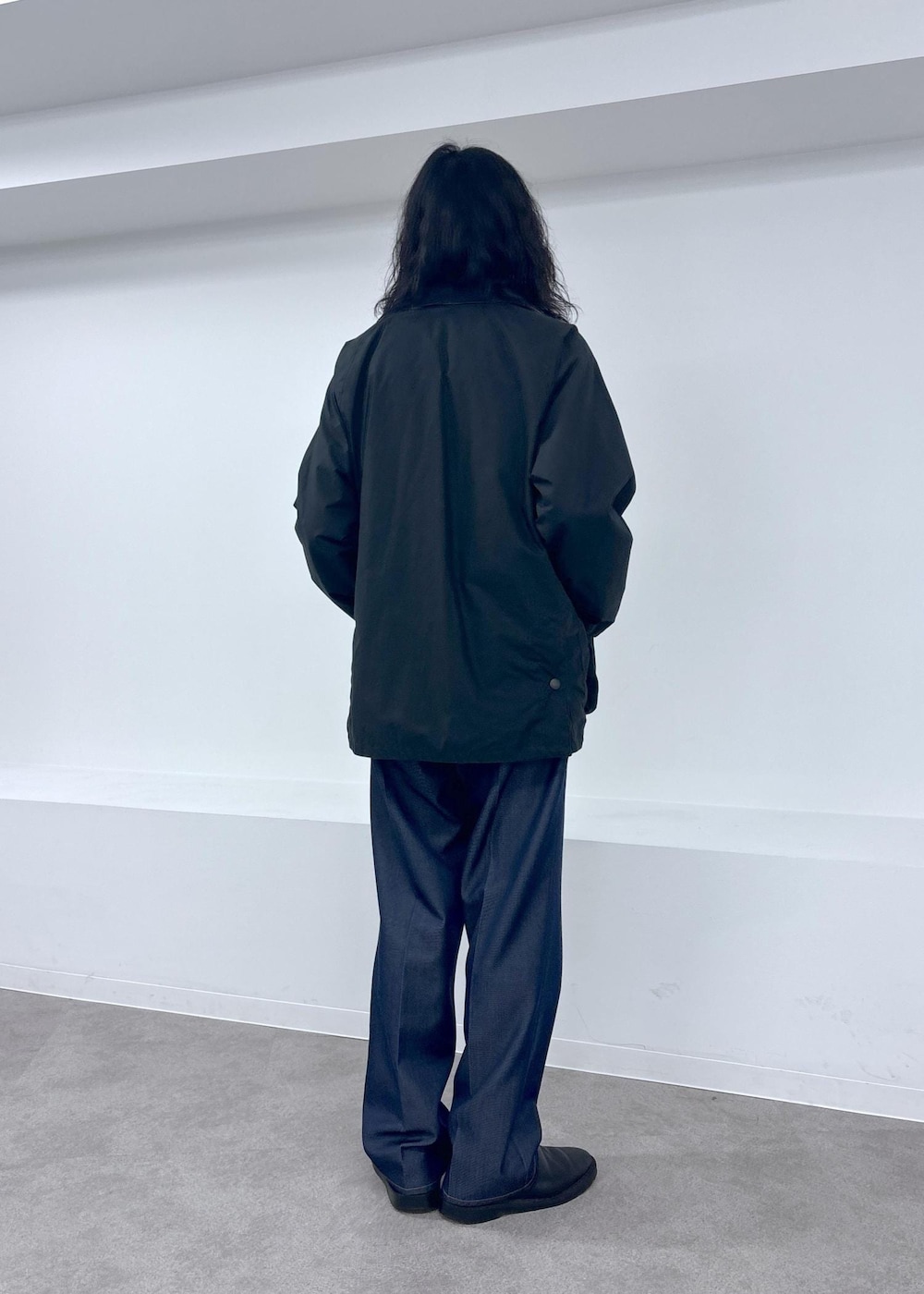 ブラック系のブルゾン、ブルー系のデニムパンツを着用したメンズの夏コーディネートの3枚目の写真