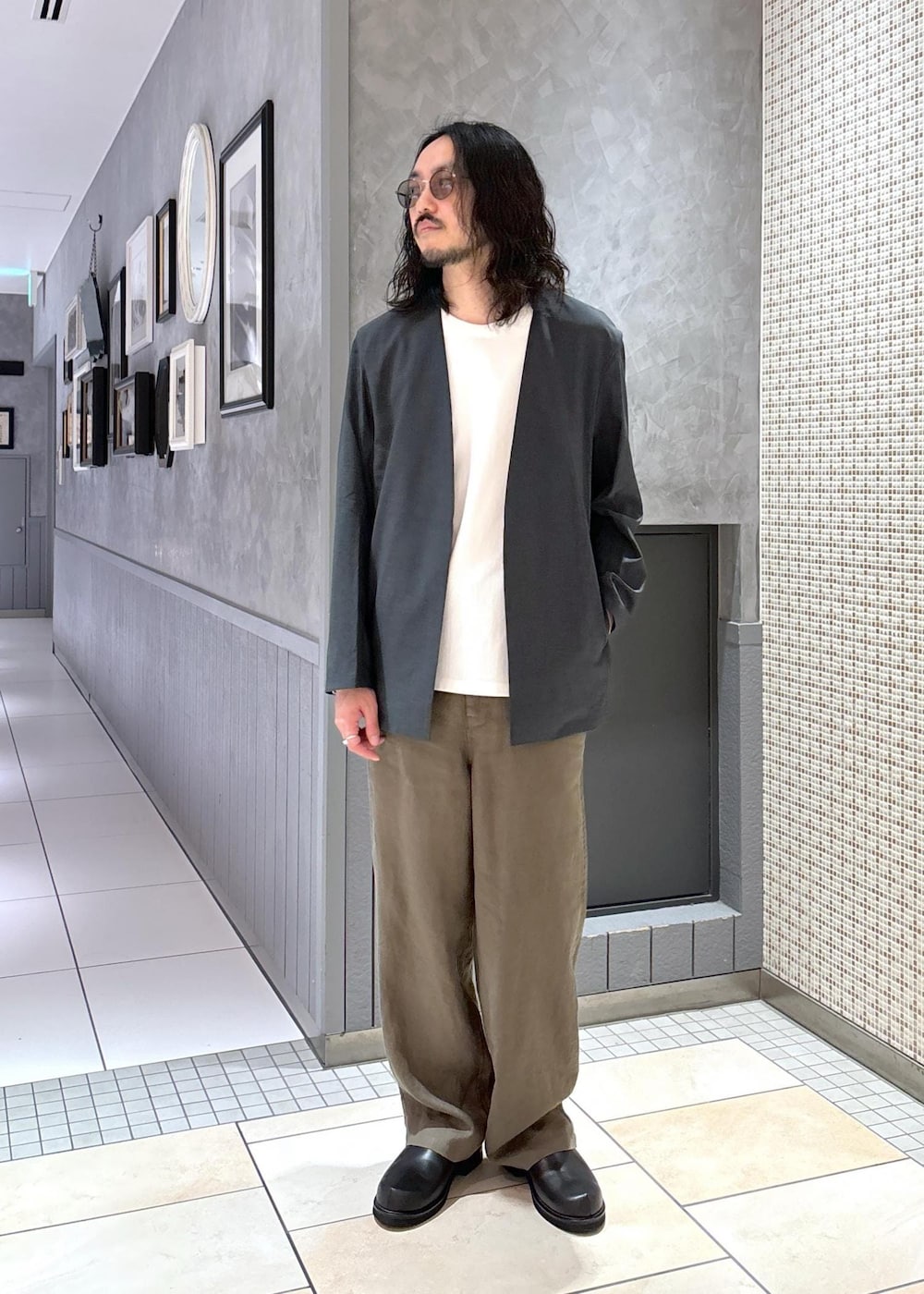 グリーン系のセットアップ、ホワイト系のTシャツ/カットソー、グリーン系のスラックスを着用したメンズの春コーディネートの2枚目の写真