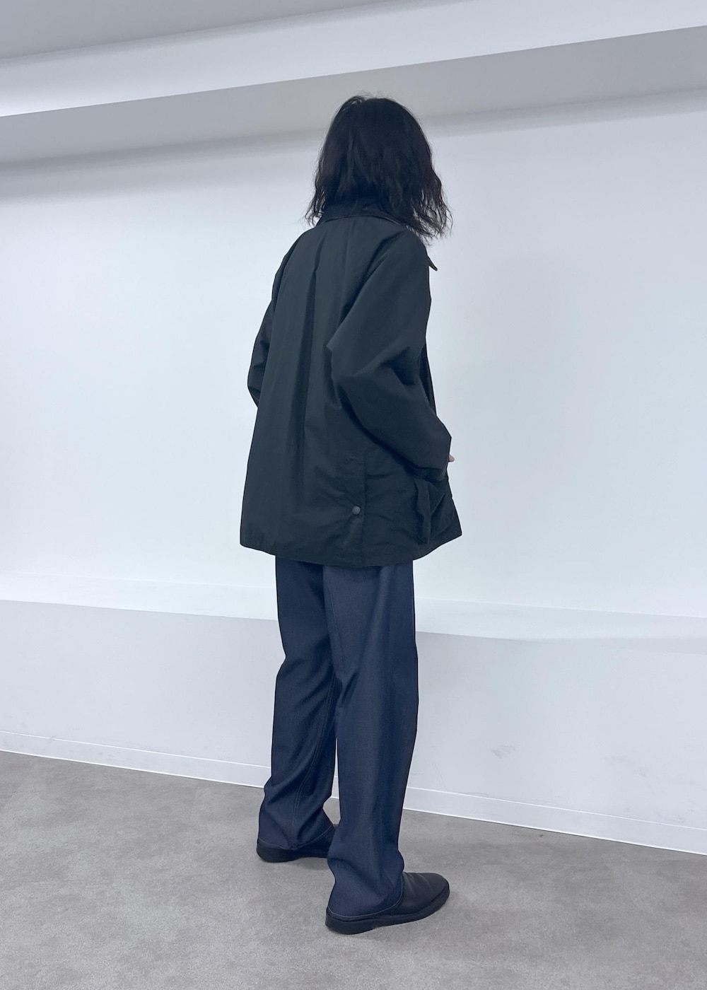 ブラック系のブルゾン、ブルー系のデニムパンツを着用したメンズの夏コーディネートの4枚目の写真