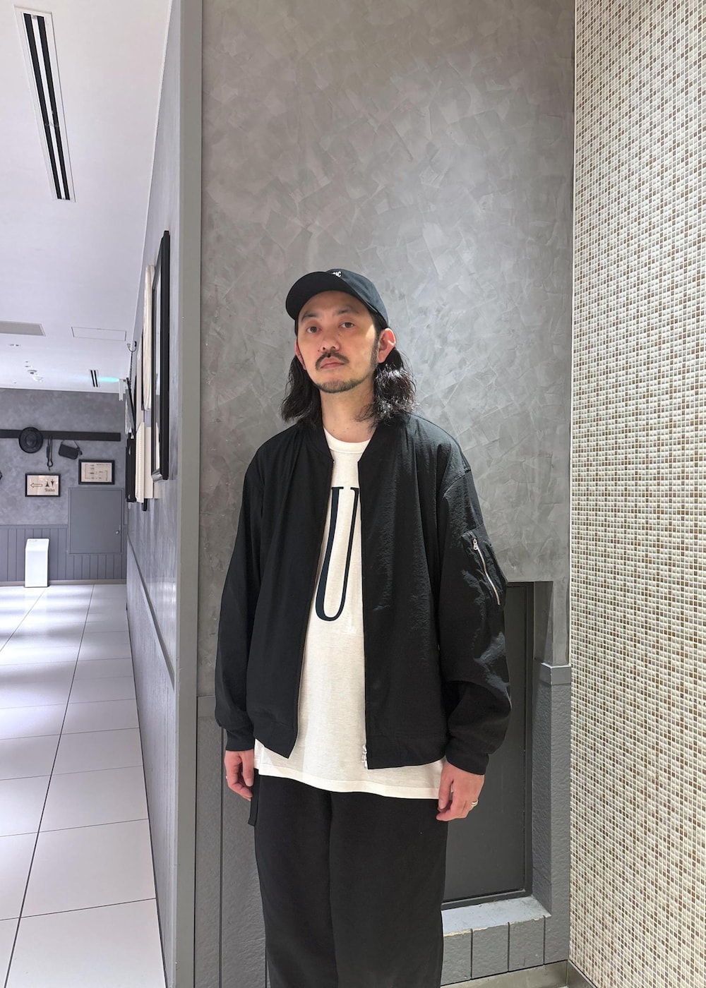 ブラック系のブルゾンを着用したメンズの春コーディネートの3枚目の写真