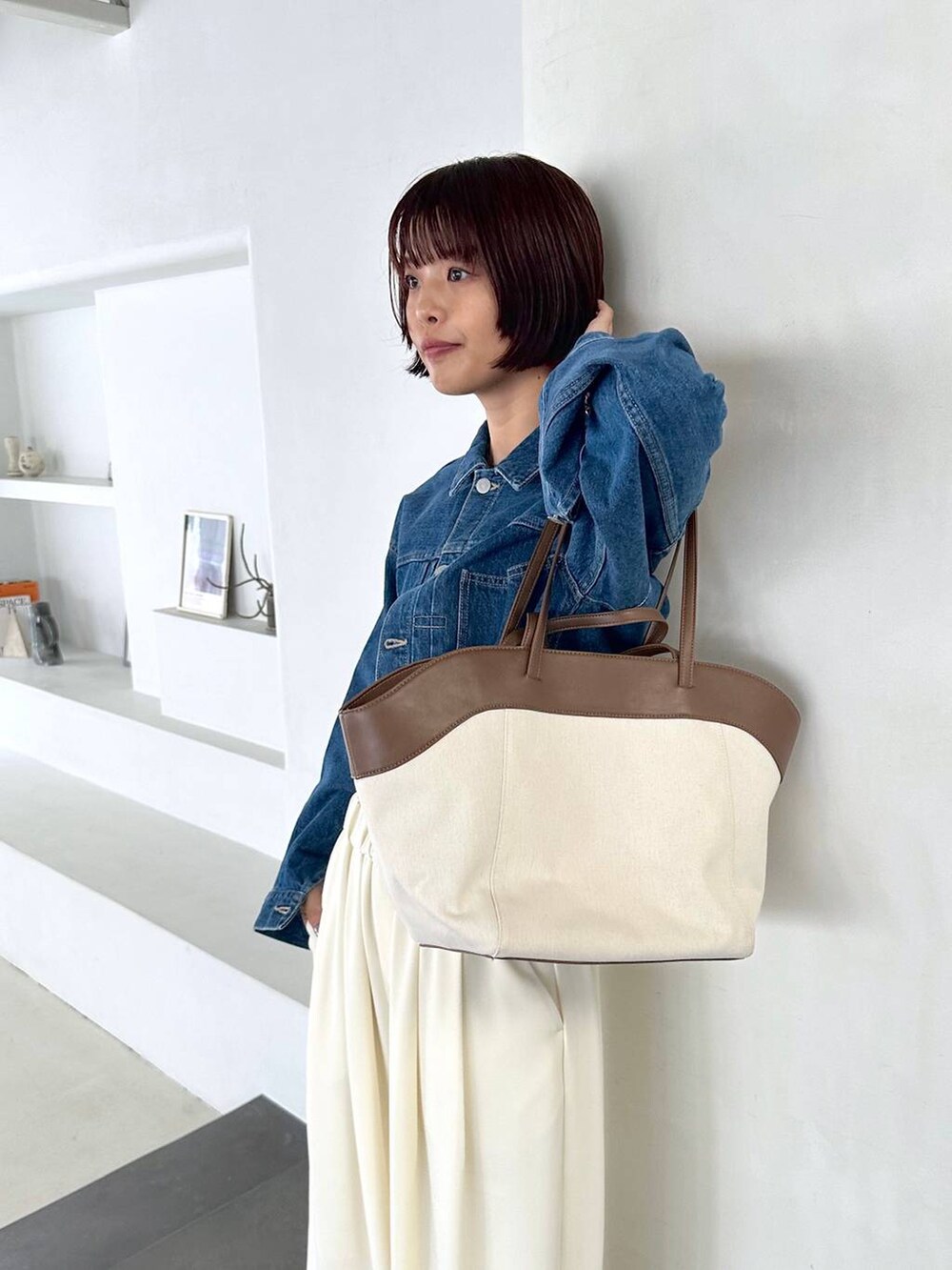 ブルー系のデニムジャケットを着用したレディースの夏コーディネートの3枚目の写真