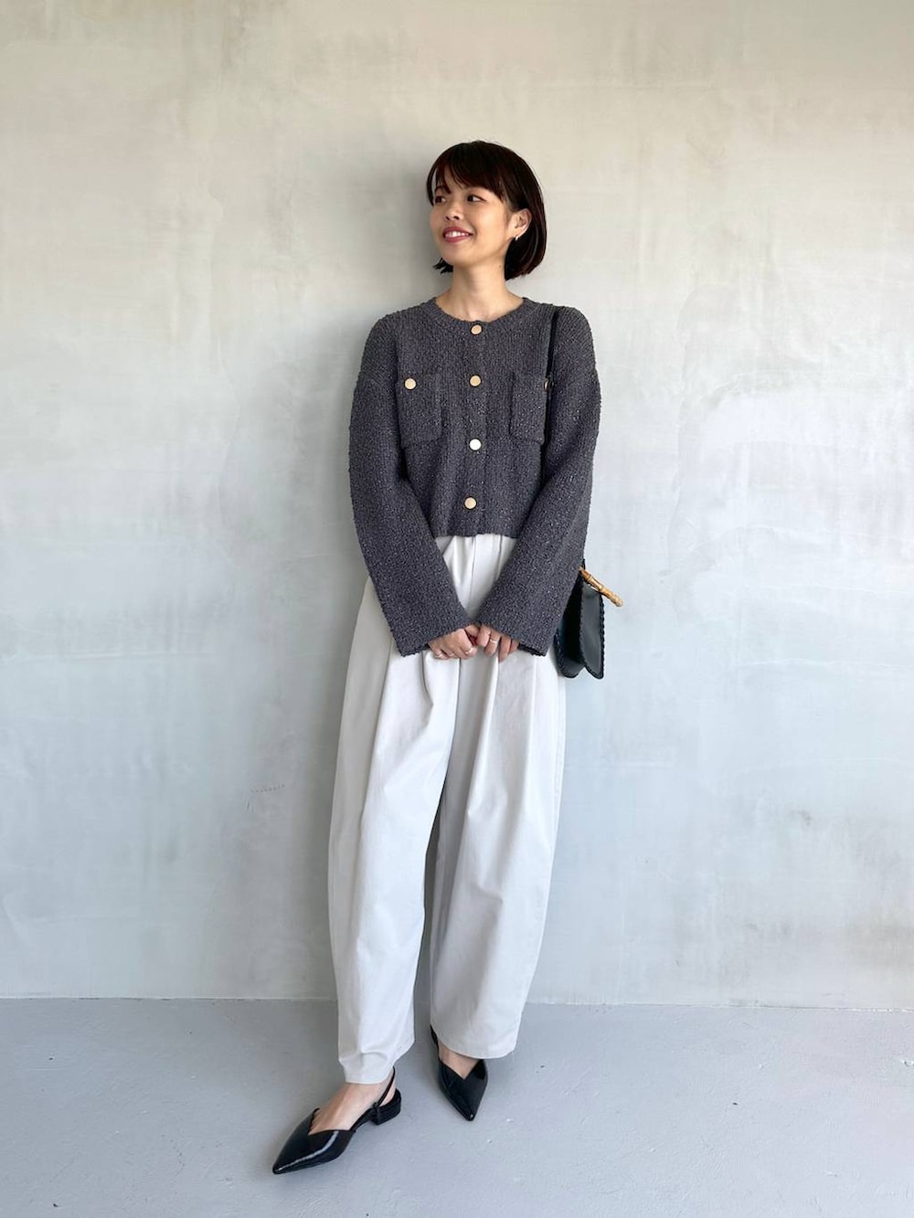 ブラック系のパンプス、グレー系のその他パンツ、グレー系のカーディガン/ボレロを着用したレディースの冬コーディネートの2枚目の写真