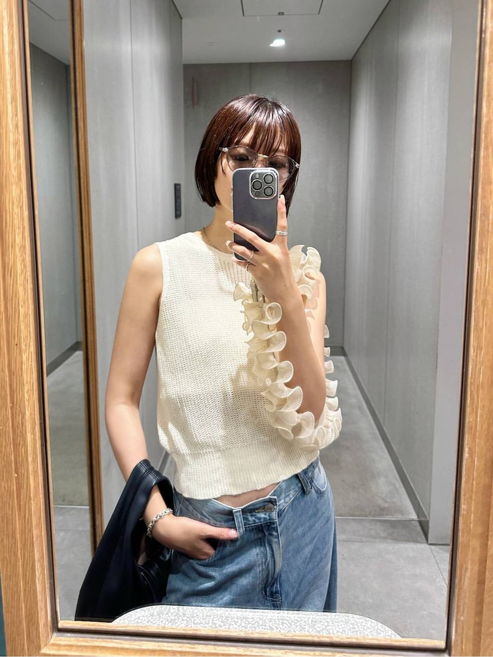 ホワイト系のタンクトップ、ブルー系のデニムパンツ、グレー系のサングラスを着用したレディースの夏コーディネートの2枚目の写真