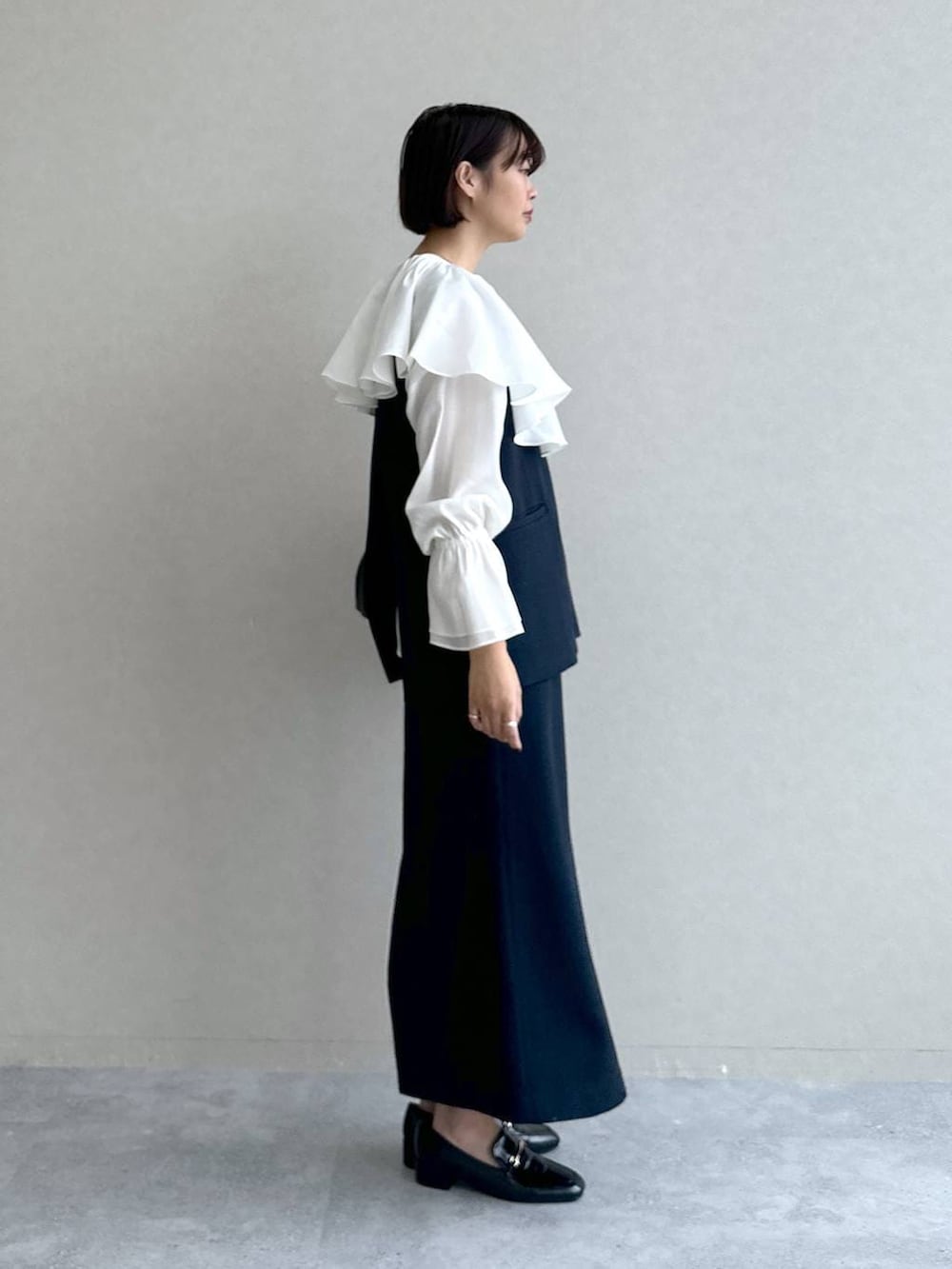 ブラック系のローファー、ブルー系のワンピース、ブラック系のショルダーバッグを着用したレディースの冬コーディネートの2枚目の写真