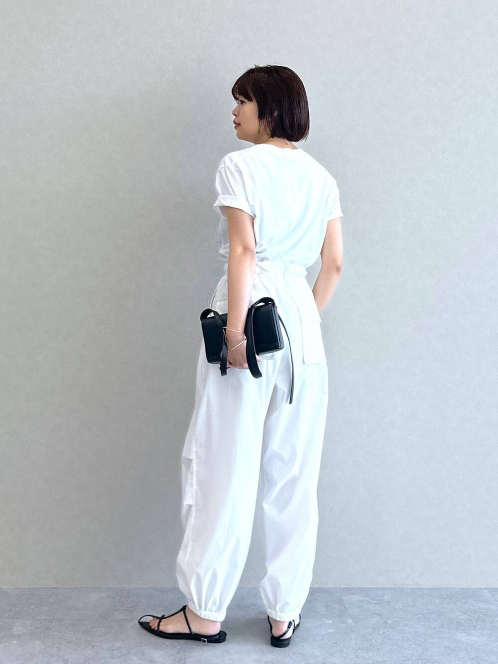 ホワイト系のTシャツ/カットソー、ホワイト系のカーゴパンツ、ブラック系のショルダーバッグを着用したレディースの夏コーディネートの5枚目の写真