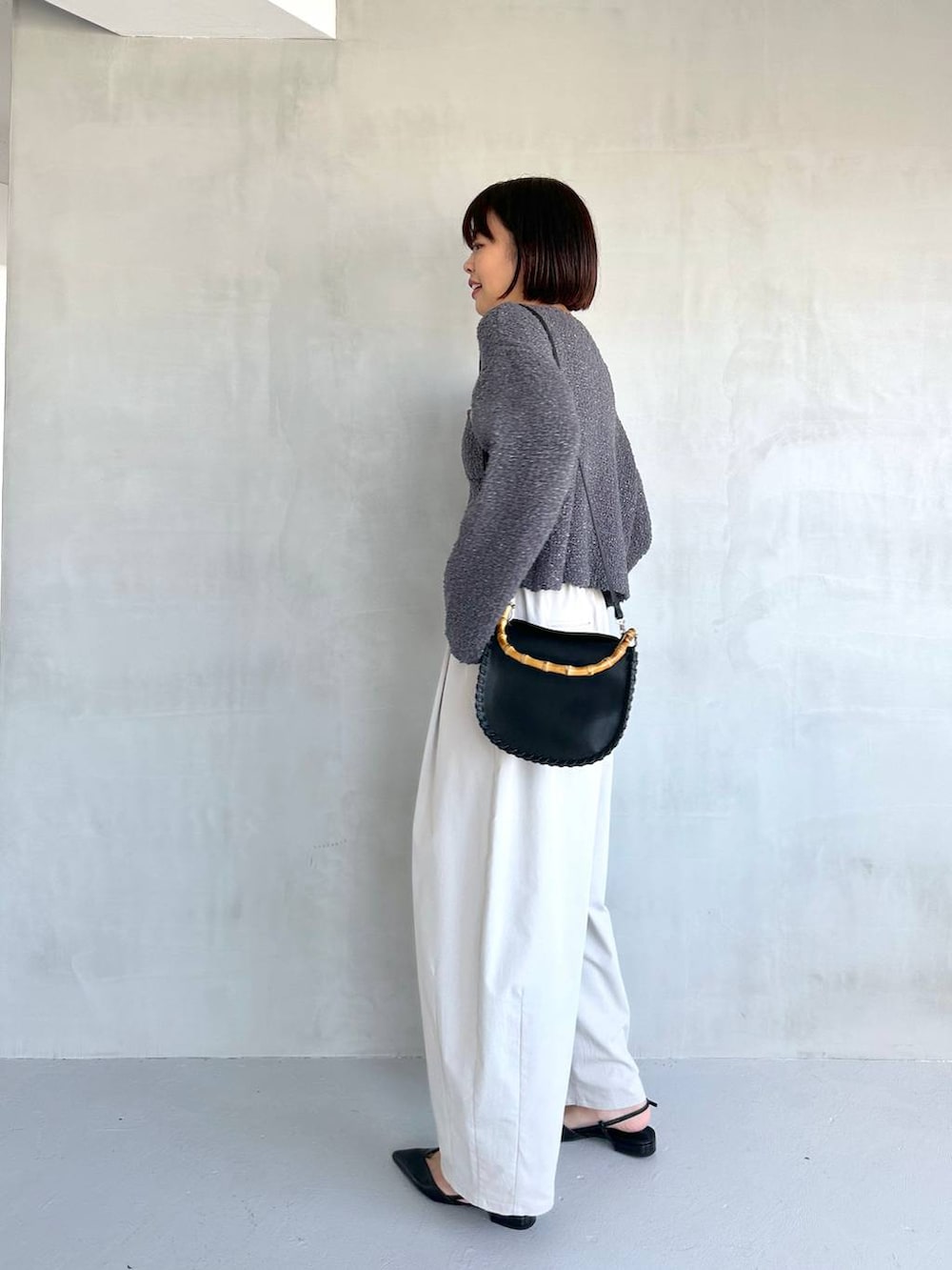 ブラック系のパンプス、グレー系のその他パンツ、グレー系のカーディガン/ボレロを着用したレディースの冬コーディネートの3枚目の写真