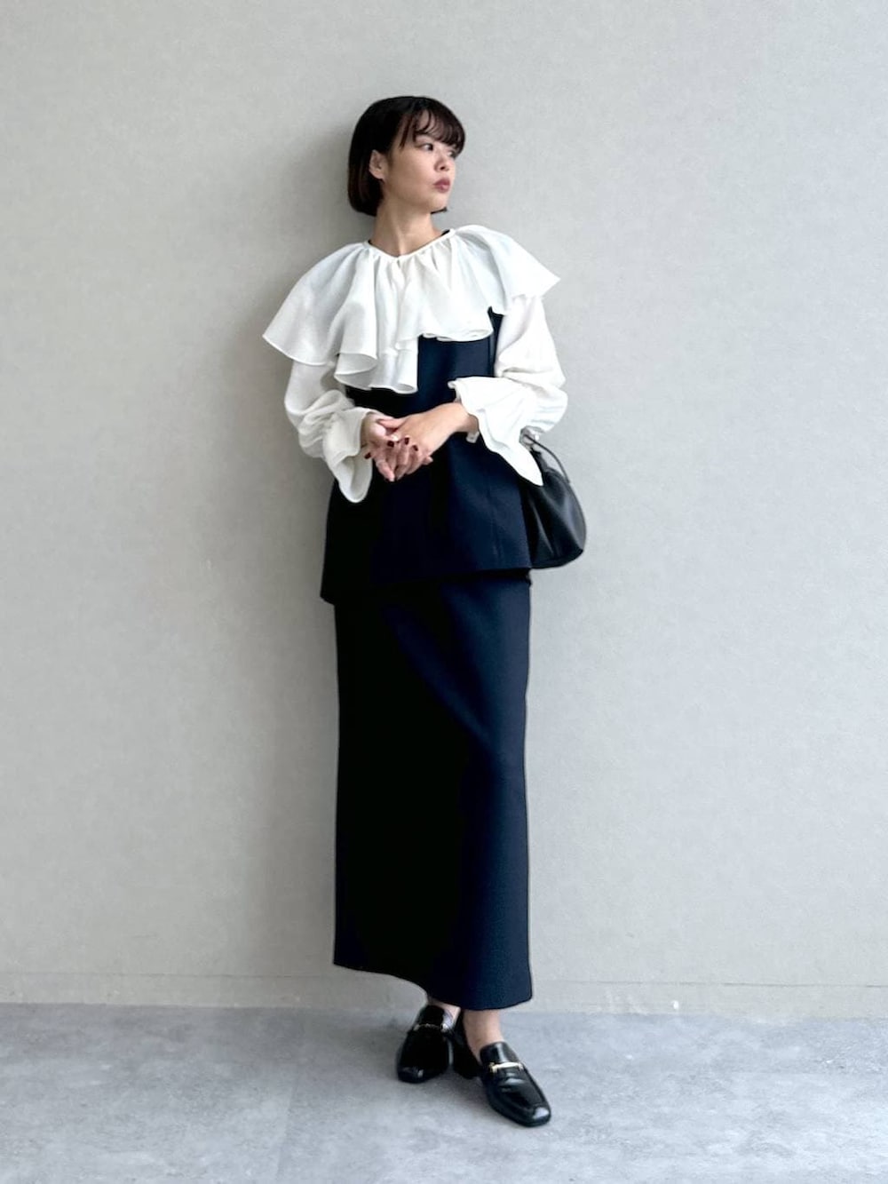 ブラック系のローファー、ブルー系のワンピース、ブラック系のショルダーバッグを着用したレディースの冬コーディネートの5枚目の写真