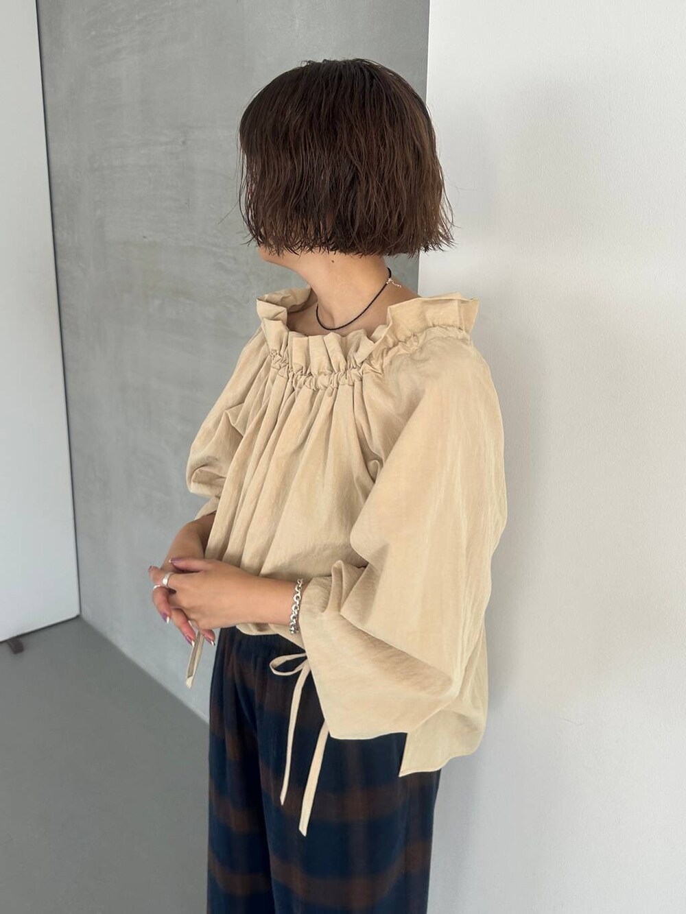 ブラウン系のパンプス、ブルー系のその他パンツ、ブラック系のネックレスを着用したレディースの秋コーディネートの4枚目の写真