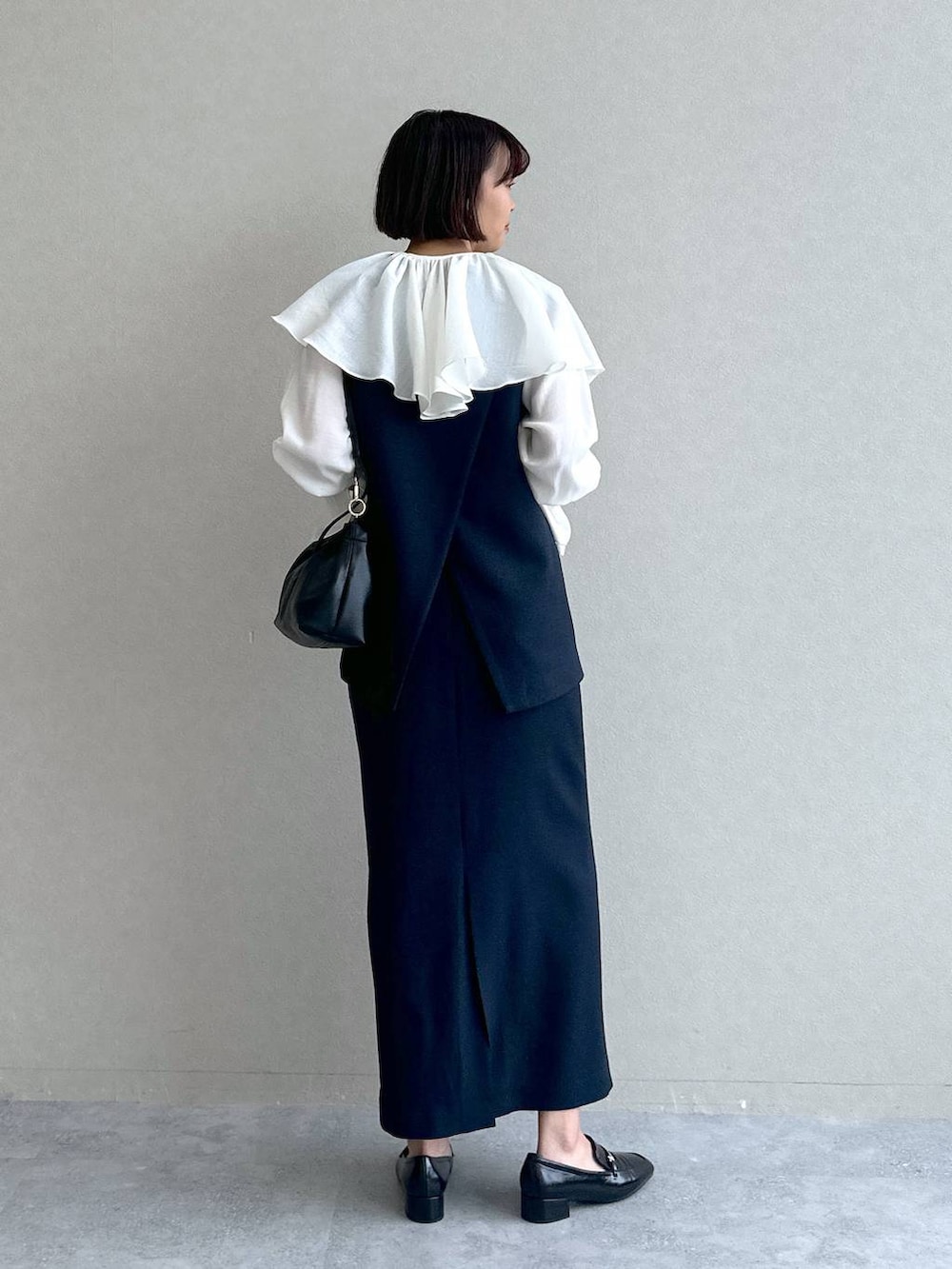 ブラック系のローファー、ブルー系のワンピース、ブラック系のショルダーバッグを着用したレディースの冬コーディネートの4枚目の写真