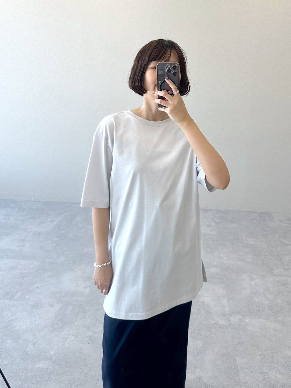 ブラック系のブーツ、ブルー系のスカート、グレー系のTシャツ/カットソーを着用したレディースの秋コーディネートの3枚目の写真