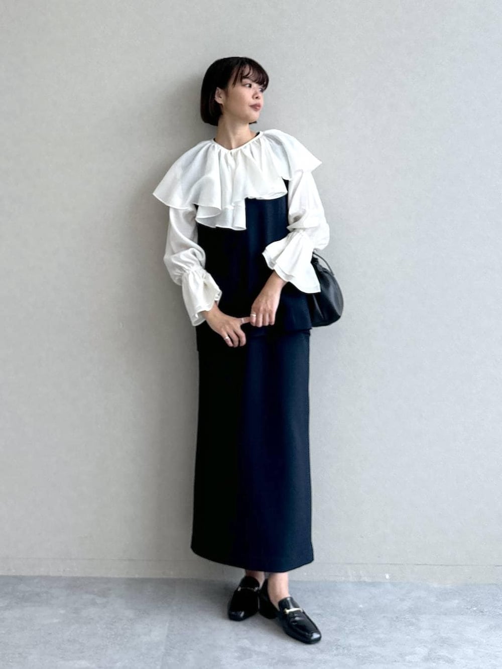 ブラック系のローファー、ブルー系のワンピース、ブラック系のショルダーバッグを着用したレディースの冬コーディネートの3枚目の写真