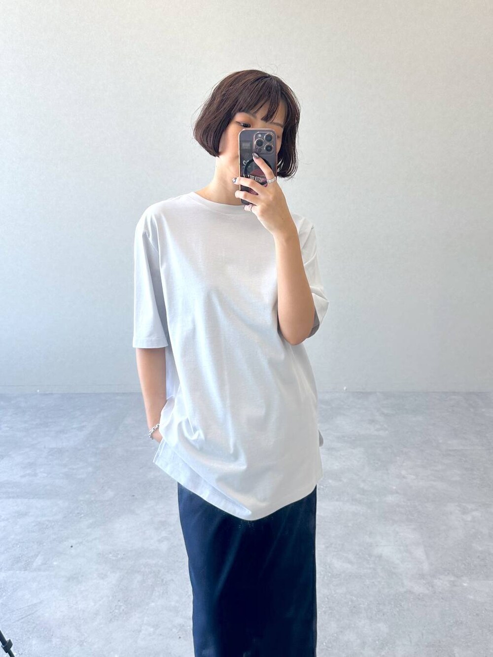 ブラック系のブーツ、ブルー系のスカート、グレー系のTシャツ/カットソーを着用したレディースの秋コーディネートの4枚目の写真