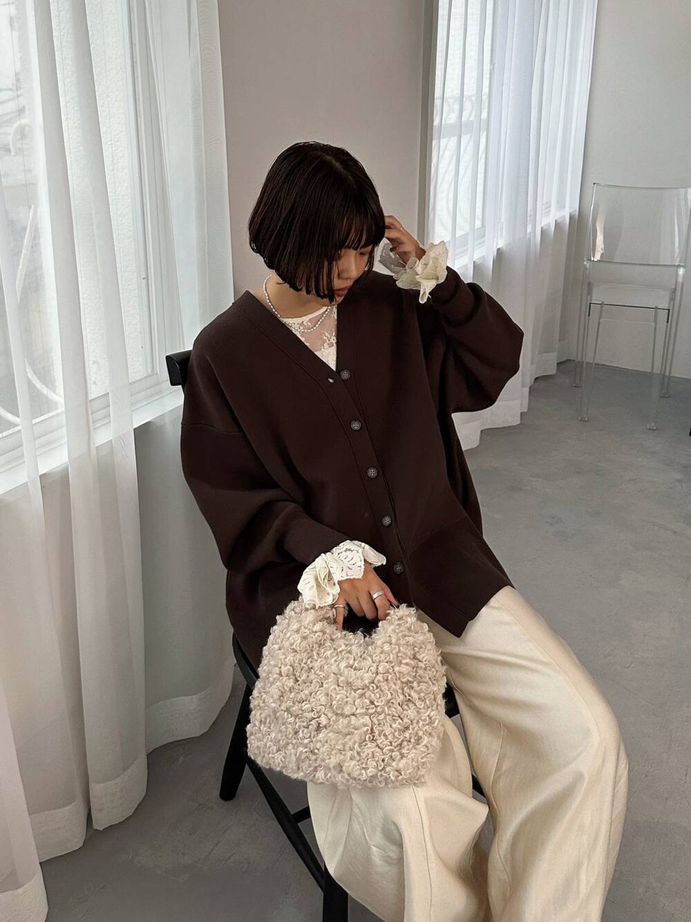 ブラウン系のカーディガン/ボレロ、ホワイト系のその他パンツ、ホワイト系のシャツ/ブラウスを着用したレディースの秋コーディネートの4枚目の写真