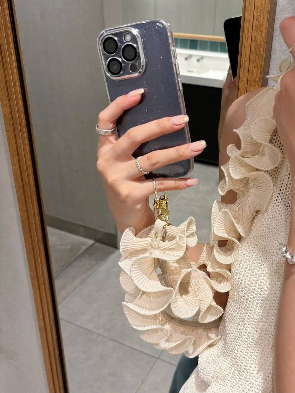 ホワイト系のタンクトップ、ブルー系のデニムパンツ、グレー系のサングラスを着用したレディースの夏コーディネートの3枚目の写真