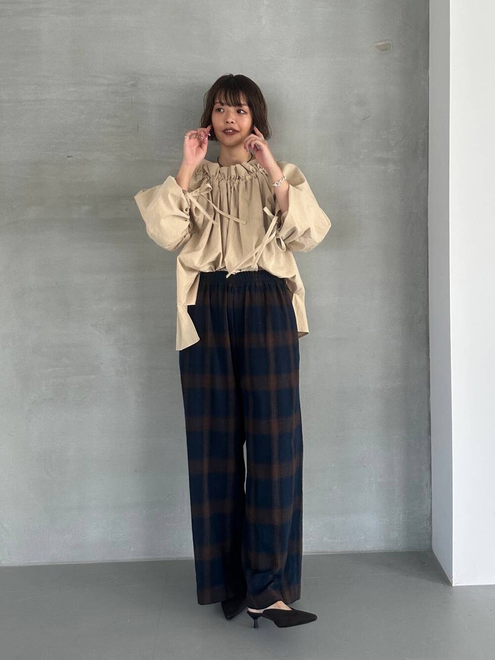 ブラウン系のパンプス、ブルー系のその他パンツ、ブラック系のネックレスを着用したレディースの秋コーディネートの2枚目の写真