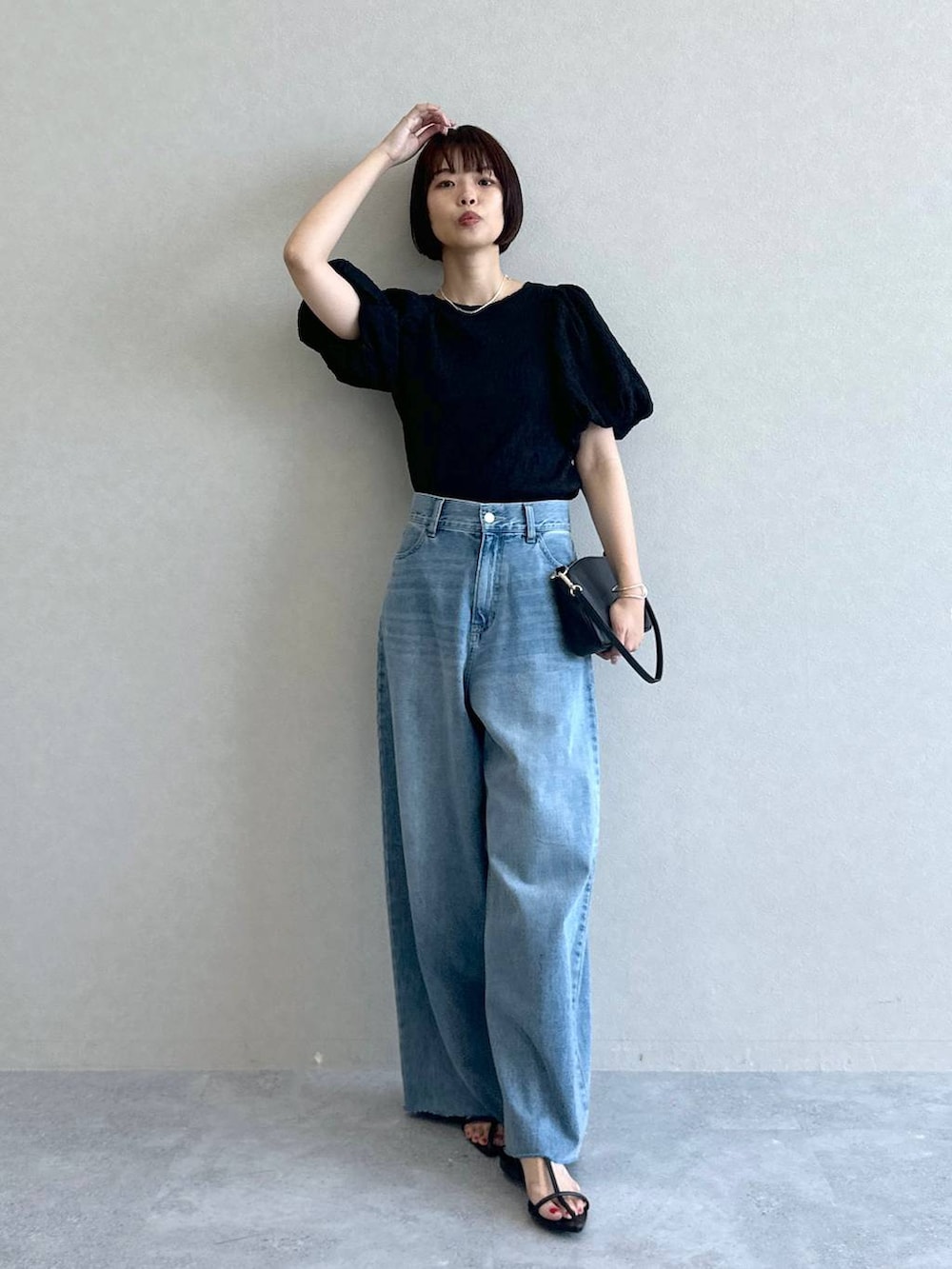 ブルー系のデニムパンツ、ブラック系のショルダーバッグ、ブラック系のサンダルを着用したレディースの春コーディネートの7枚目の写真