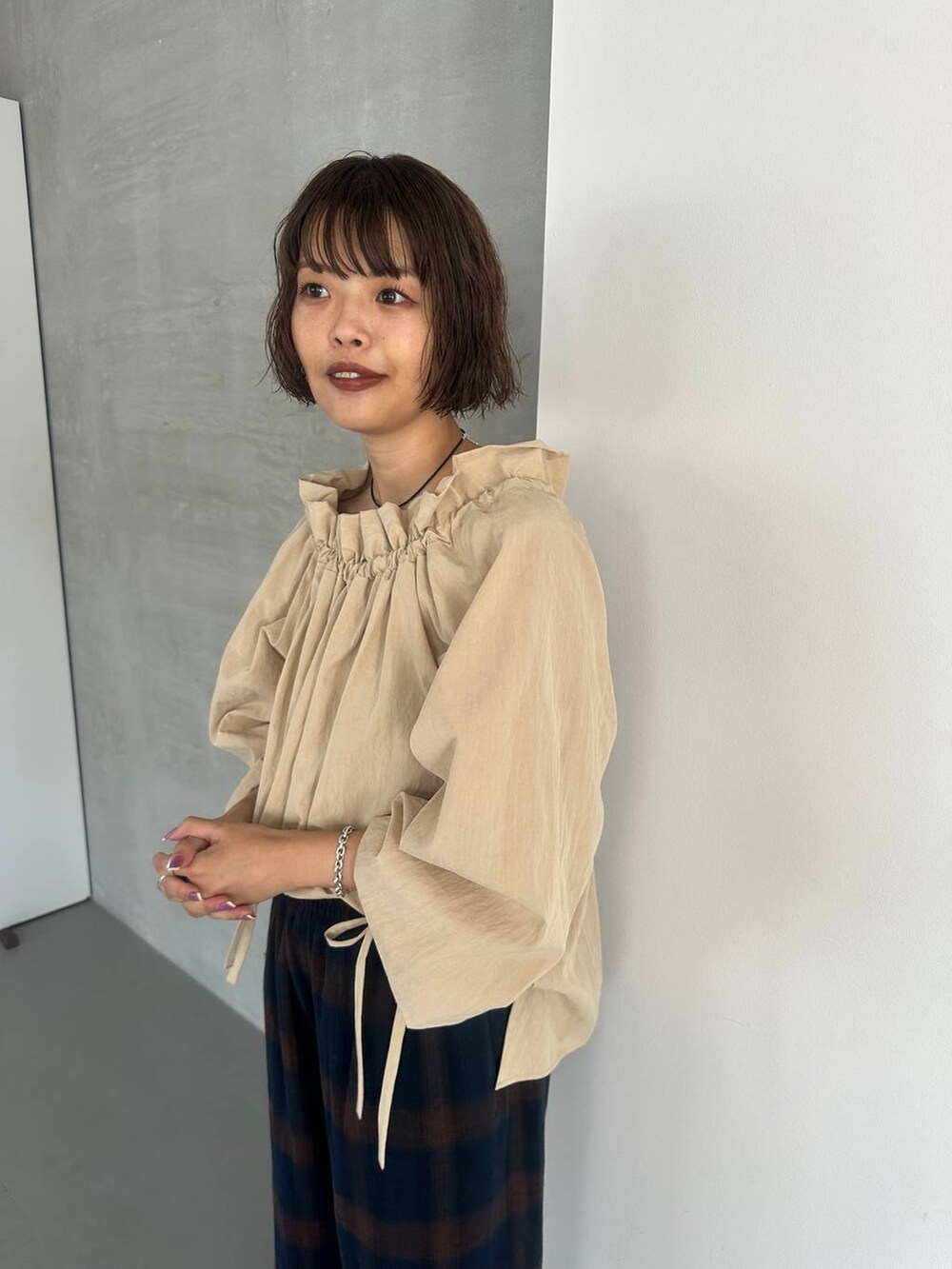 ブラウン系のパンプス、ブルー系のその他パンツ、ブラック系のネックレスを着用したレディースの秋コーディネートの3枚目の写真