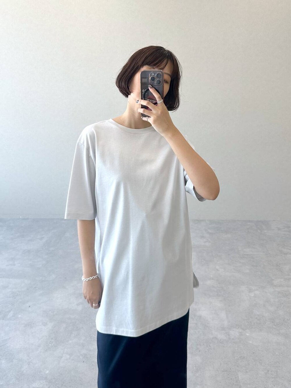 ブラック系のブーツ、ブルー系のスカート、グレー系のTシャツ/カットソーを着用したレディースの秋コーディネートの2枚目の写真