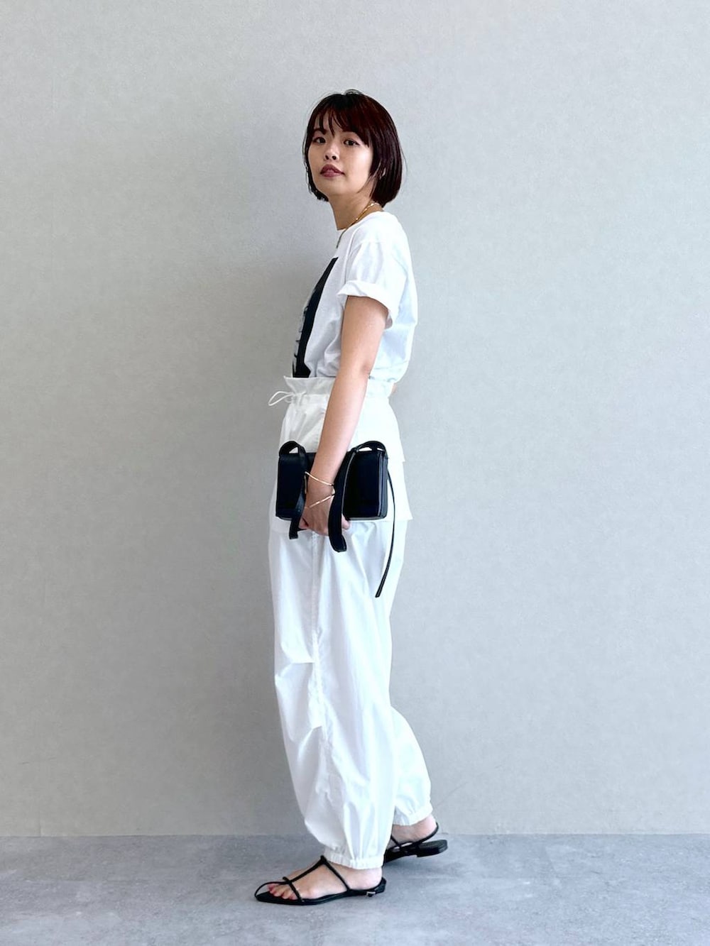 ホワイト系のTシャツ/カットソー、ホワイト系のカーゴパンツ、ブラック系のショルダーバッグを着用したレディースの夏コーディネートの6枚目の写真