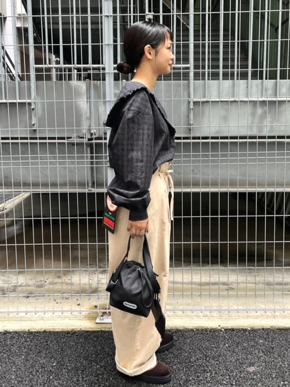 ブラック系のショルダーバッグ、ブルー系のシャツ/ブラウス、ベージュ系のその他パンツを着用したレディースの秋コーディネートの2枚目の写真