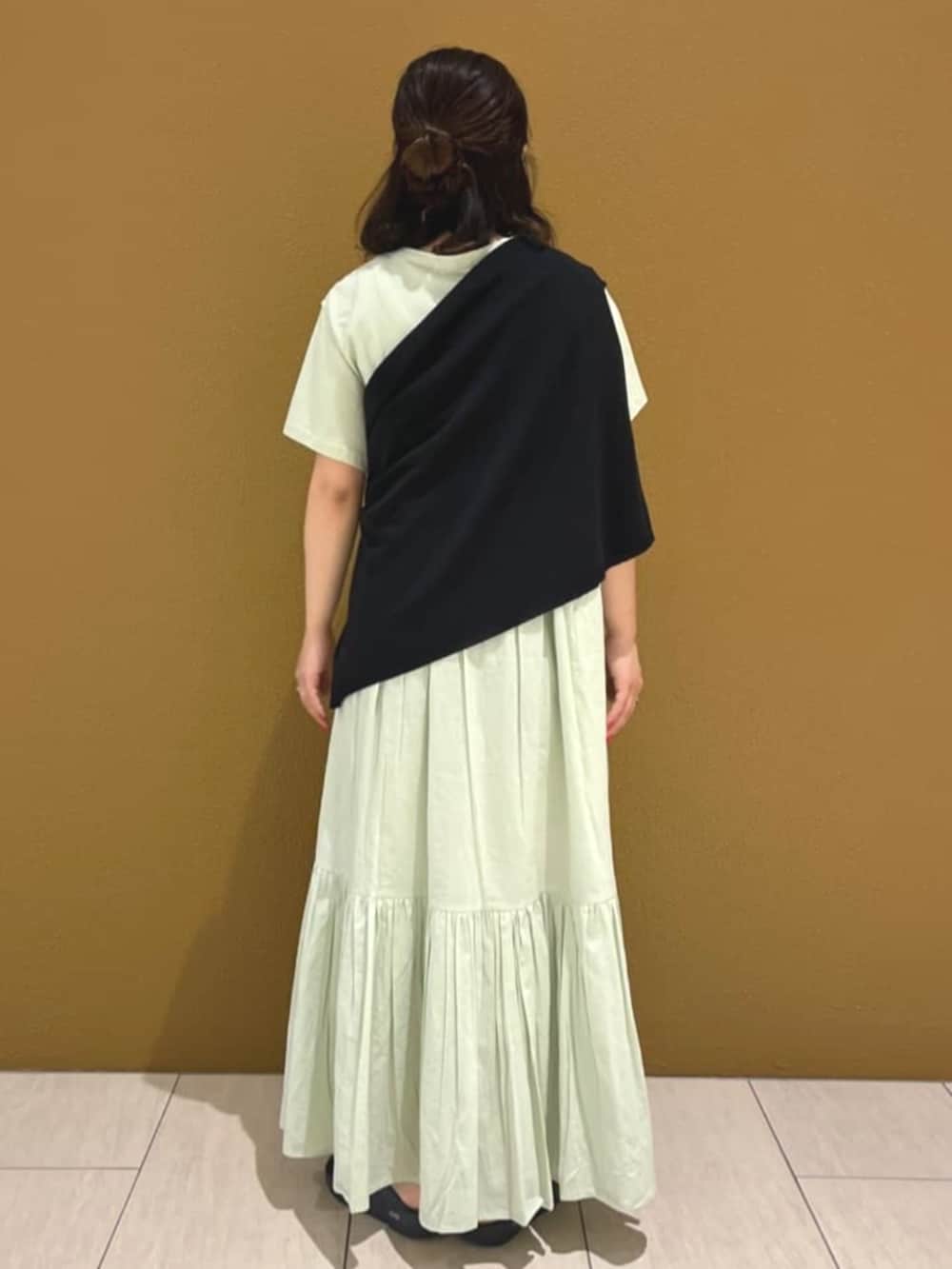 ブルー系のワンピース、ブラック系のニット/セーター、ブラック系のサンダルを着用したレディースの春コーディネートの3枚目の写真