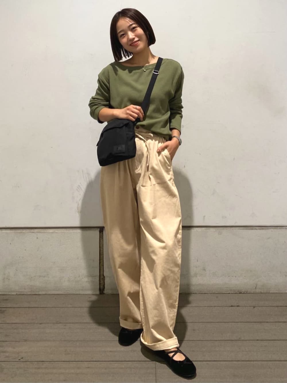 ベージュ系のその他パンツ、グリーン系のTシャツ/カットソー、ブラウン系のバレエシューズを着用したレディースの秋コーディネートの5枚目の写真