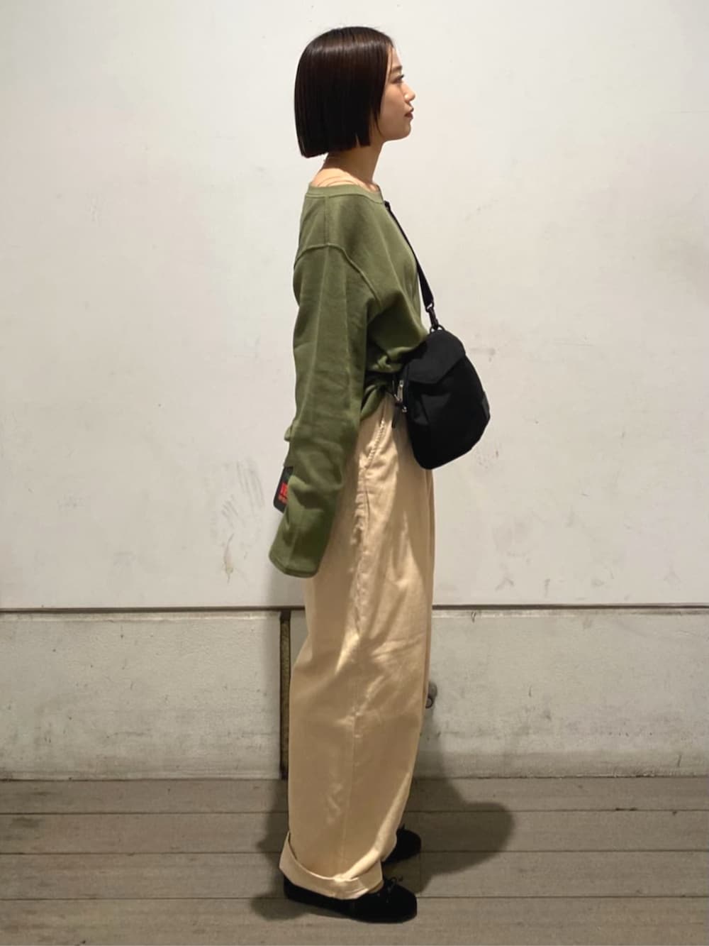 ベージュ系のその他パンツ、グリーン系のTシャツ/カットソー、ブラウン系のバレエシューズを着用したレディースの秋コーディネートの2枚目の写真
